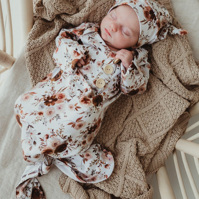 Sweet little baby wearing a snuggly jacks knotted gown and beanie