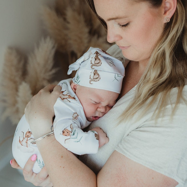 Mum getting snuggles from her little bundle of joy who is all wrapped up in a knotted gown