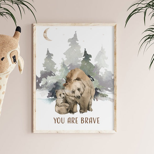 Picture of a brown bear and her cub walking in the forest, in a brown frame hanging on a nursery room wall